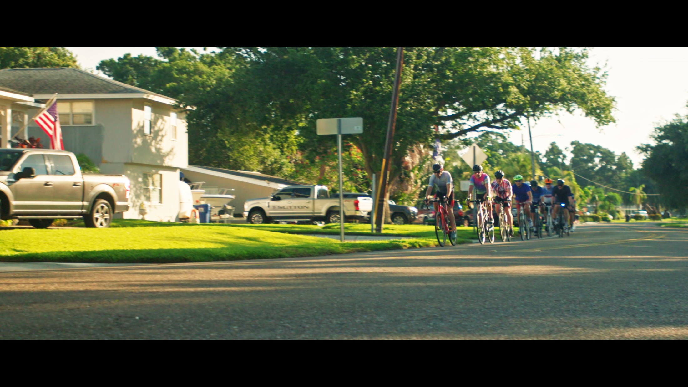 Cyclists ride side by side in the Florida light.